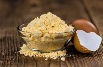 Egg Proteinpulver Löffel neben frischen Eiern und Shaker.