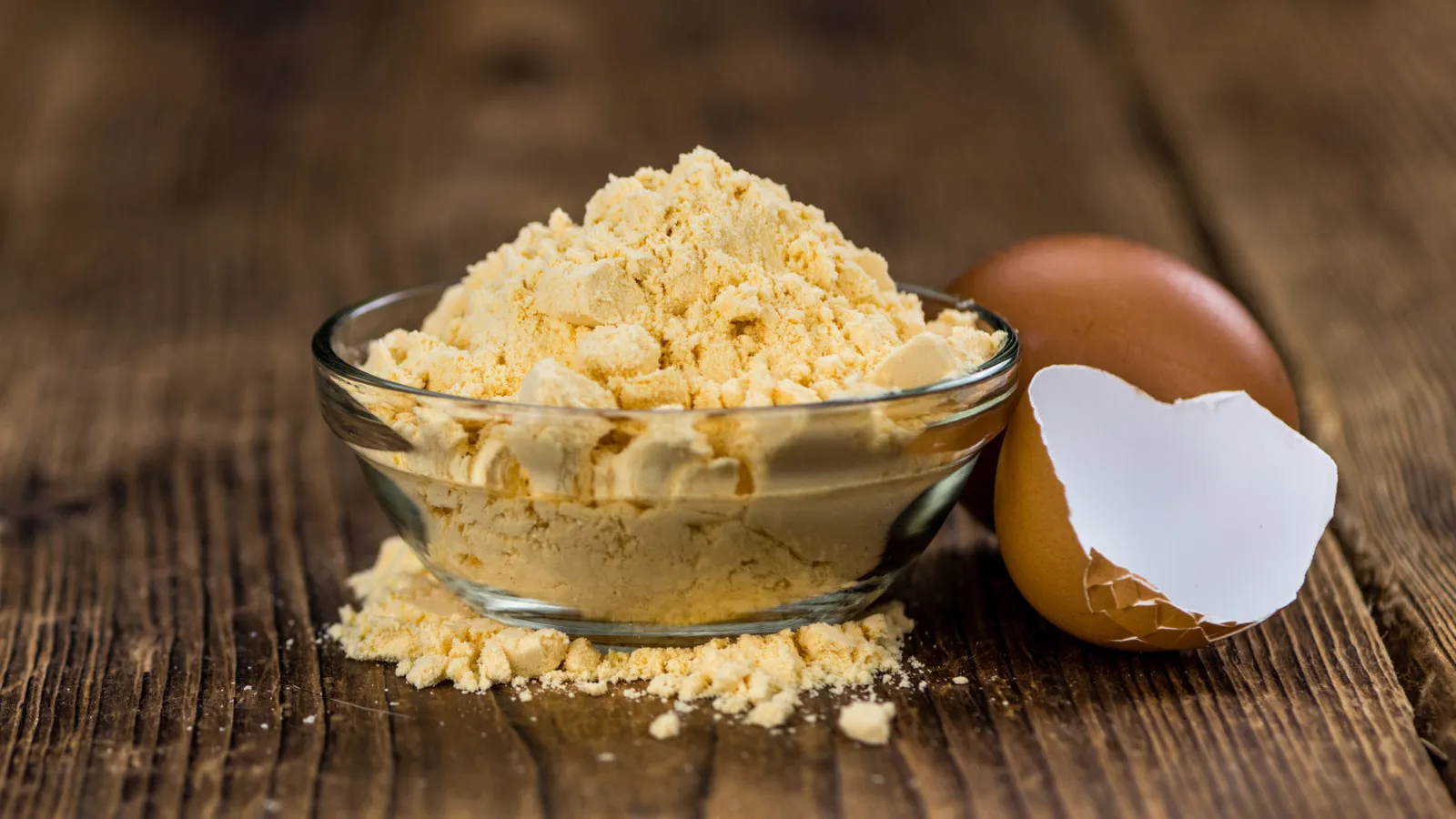 Egg Proteinpulver Löffel neben frischen Eiern und Shaker.